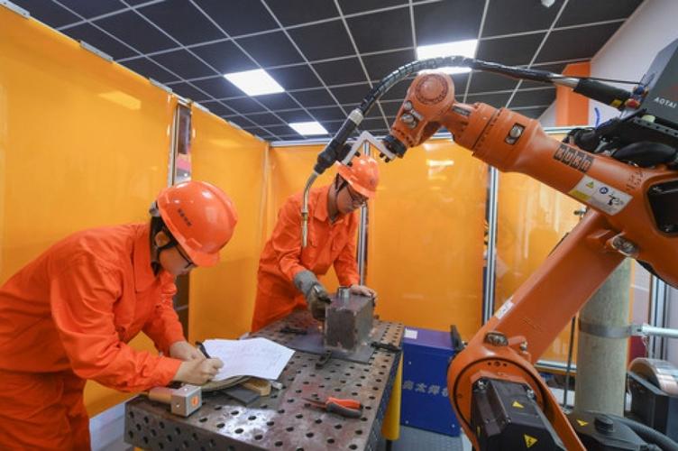 9月5日,参赛的工业机器人系统操作员在比赛中观察设计机器人的焊接
